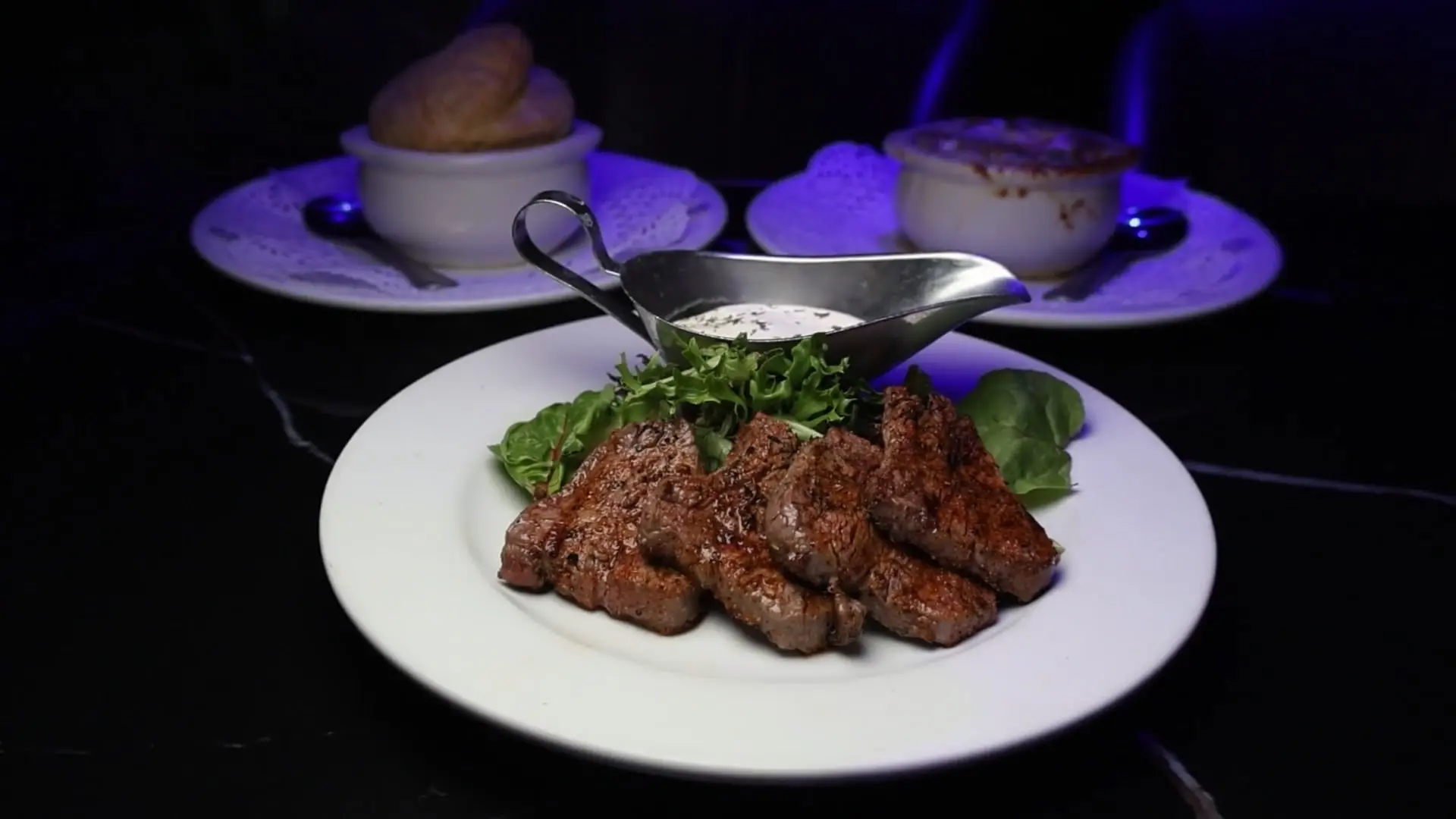 Grilled steak with sauce and greens