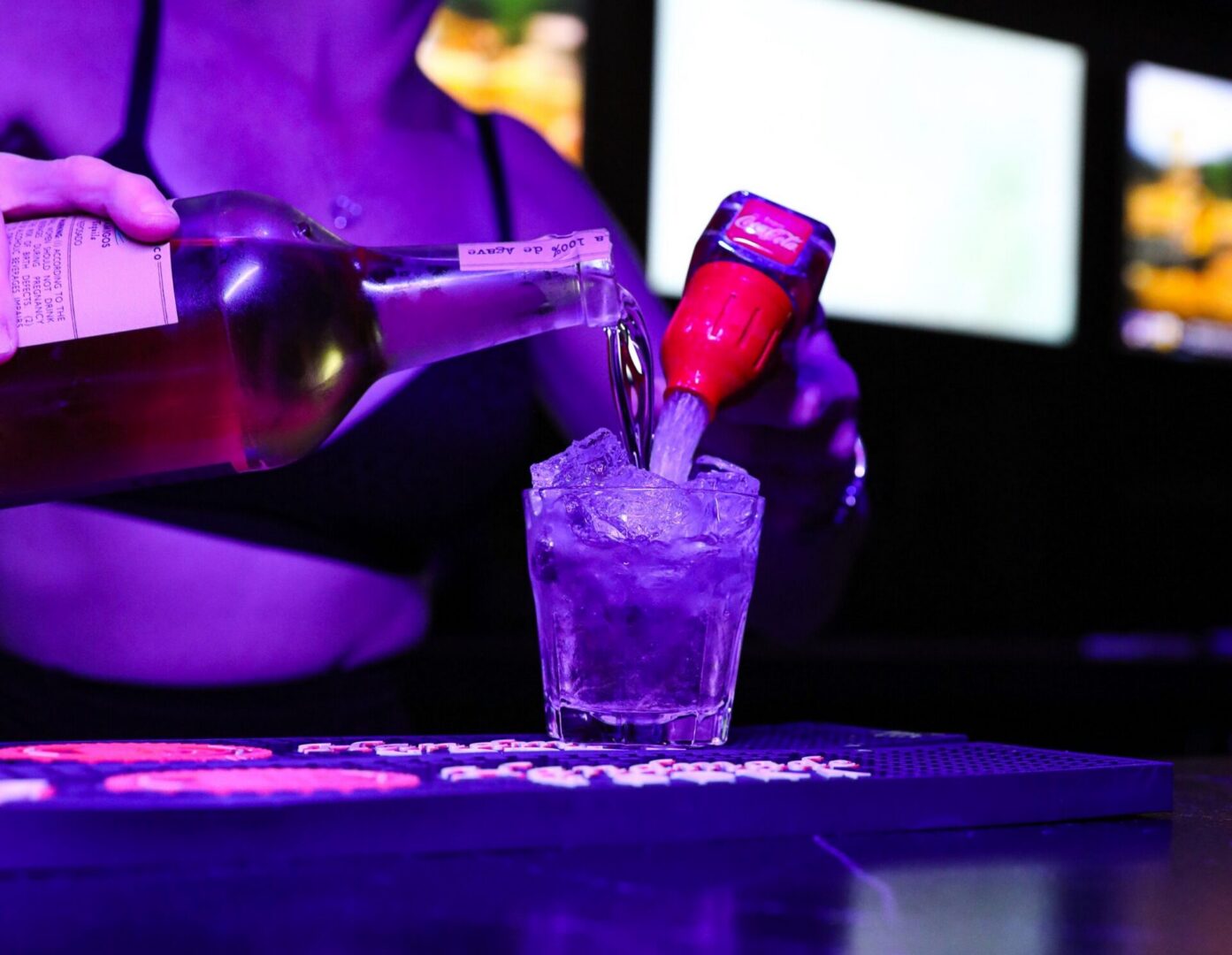 Bartender pouring drinks into a glass