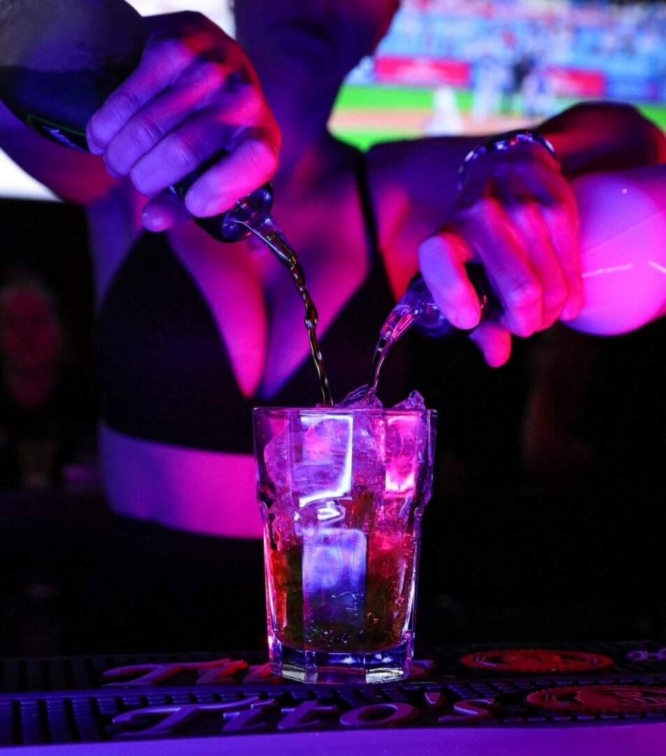 Bartender pouring drinks under neon lights